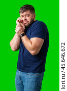 Man expressing frustration with tired eyes while standing in front of a bright green background. Стоковое фото, фотограф Сергей Толмачёв / Фотобанк Лори