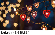 The concept of Valentine's Day, a banner with garlands in the form of hearts and magic lights for a holiday filled with love. A place for the text. Стоковое AI-изображение, AI-художник Photojuli / Фотобанк Лори