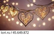 The concept of Valentine's Day, a banner with garlands in the form of hearts and magic lights for a holiday filled with love. A place for the text. Стоковое AI-изображение, AI-художник Photojuli / Фотобанк Лори