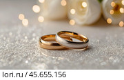 Gold wedding rings on a white background with a side. Wedding rings. The wedding day. The newlyweds. Стоковое AI-изображение, AI-художник Photojuli / Фотобанк Лори