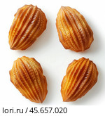 Four small fluted madeleine cakes on white background. Стоковое AI-изображение, AI-художник Иван Рябоконь / Фотобанк Лори