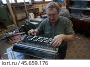 Мужчина за работой над баяном (2011 год). Редакционное фото, фотограф Дмитрий Киселёв / Фотобанк Лори
