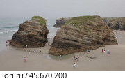 Tourists walking around iconic rock formation. Стоковое видео, видеограф Данил Руденко / Фотобанк Лори
