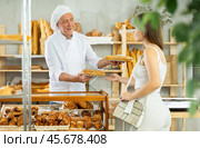 Elderly man seller gives bocadillo to woman buyer. Стоковое фото, фотограф Яков Филимонов / Фотобанк Лори