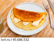 On plate - ruddy soft pancakes with pieces of tender cream brie cheese. Стоковое фото, фотограф Яков Филимонов / Фотобанк Лори