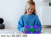 Счастливая девочка с подарочной коробкой с зелёной лентой. Стоковое AI-изображение, AI-художник Anna Leeva / Фотобанк Лори