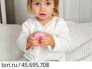 Cute baby girl playing tactile knobby balls. Young child hand plays sensory massage ball. Enhance the cognitive, physical process. Brain development. Support for Children with ADHD, autism, fidgeting. Стоковое фото, фотограф Марина Демидюк / Фотобанк Лори