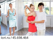 Adolescent dance duo, boy and girl, refining slow foxtrot with female coach. Стоковое фото, фотограф Яков Филимонов / Фотобанк Лори