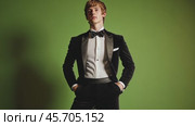 Confident young man in formal attire against green background transitions through stylish poses. Стоковое AI-видео, аниматор Sabyna75 / Фотобанк Лори