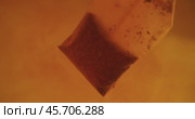 Close up of tea bag diffusing in a clear glass. Macro slow motion shot of the process of brewing herbal. Стоковое видео, видеограф Андрей Армягов / Фотобанк Лори