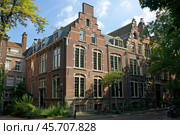 Elegant brick row houses with stepped gables basking in the summer sun in amsterdam, netherlands. Стоковое AI-изображение, AI-художник Иван Рябоконь / Фотобанк Лори