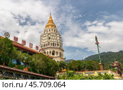 Kek Lok Si Temple in Penang, Malaysia featuring stunning pagoda, intricate architecture, lush greenery, grand staircase leading to temple entrance under partly cloudy sky. Стоковое фото, фотограф Павел Муравьев / Фотобанк Лори