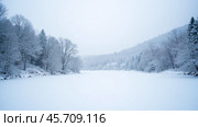 Snowy winter landscape with frozen river surrounded by snow-covered trees and hills, serene and peaceful nature scene, winter themed project. Стоковое AI-изображение, AI-художник Павел Муравьев / Фотобанк Лори