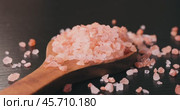 Himalayan pink salt in a wooden is used to flavor food. Due mainly to marketing costs, pink Himalayan salt is up to twenty times more expensive than table or sea salt. Стоковое видео, видеограф Андрей Армягов / Фотобанк Лори