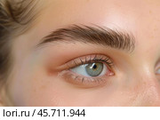 Woman showing result of eyebrow tattooing and lamination treatment. Стоковое AI-изображение, AI-художник Иван Рябоконь / Фотобанк Лори