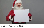 Cheerful Santa Claus Holding a Blank Sign Mock Up with Space for Your Text, Holiday Promotions and Events. Jolly Santa Claus gesturing pointing on white banner placard, festive themes advertising. Стоковое AI-видео, аниматор Марина Демидюк / Фотобанк Лори