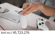 Man sits at computer desk, close-up on his hand opening energy drink. Surrounded by gaming accessories like keyboard, joystick, and mouse pad, scene captures focused vibe of intense gaming session. Стоковое видео, видеограф Енваев Андрей / Фотобанк Лори