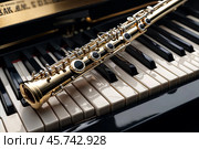 Close-up of gold flute on black white piano keys. Flute with piano, wind instrument for musical design of concert creativity. Music orchestra concert concept. Copy ad text space. Copy ad text space. Стоковое AI-изображение, AI-художник Aleksandr Golubev / Фотобанк Лори