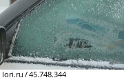 A person cleaning the side windows of a car from snow with ice scraper. Woman removes ice from car windows. Female hand cleans car with special tool in snowy winter day. Slow motion 120fps. Стоковое видео, видеограф Мария Зубарева / Фотобанк Лори