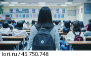 Young Asian woman during class in the university. Girl with backpack standing in a classroom. Female student attentively facing forward at lecture hall. Rear view. Knowledge in learning environment. Стоковое AI-видео, аниматор Марина Демидюк / Фотобанк Лори