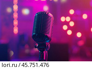 Microphone on the stage in concert hall or conference room. Close-up of a microphone in focus with a blurred pink purple bokeh background. Public speaking and live events concept. Neon light. Audience. Стоковое AI-изображение, AI-художник Марина Демидюк / Фотобанк Лори