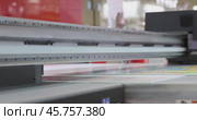 Modern Digital Large format UV printer. Printing production technologies. UV pinning is the process of applying a dose of low intensity ultraviolet light to a UV curable ink. Стоковое видео, видеограф Андрей Армягов / Фотобанк Лори