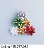 Top view of creative fir tree made of colourful holiday bows on grey-blue background. Стоковое фото, фотограф Юлия Трикашная / Фотобанк Лори