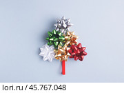 Creative fir tree made of holiday bow and ribbon on gray-blue background. Стоковое фото, фотограф Юлия Трикашная / Фотобанк Лори