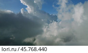 A sky filled with fluffy white cumulus clouds over a natural landscape. Стоковое видео, видеограф Степанов Григорий / Фотобанк Лори