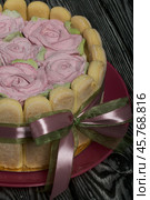 Cake with Savoiardi cookies and marshmallow roses. Tied with ribbon. The ribbon is tied into a bow. Стоковое фото, фотограф Vadzim Yakubovich / Фотобанк Лори