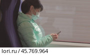 Woman wearing a protective medical face mask rides on a train during the covid 19 quarantine. Стоковое видео, видеограф Андрей Армягов / Фотобанк Лори