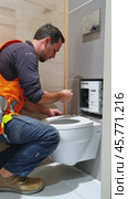 Plumber installing a wall hung toilet in a modern bathroom. Стоковое AI-видео, аниматор Юрий Поздников / Фотобанк Лори