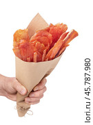 Hand holding paper bag full of pork, chicken and turkey meat chips isolated on white background. Стоковое фото, фотограф Сергей Чайко / Фотобанк Лори