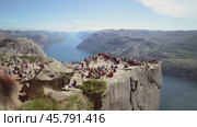 NORWAY- June 15, 2019: Preikestolen or Prekestolen, also known by the English translations of Preacher's Pulpit or Pulpit Rock, is a famous tourist attraction in Forsand, Ryfylke, Norway (2020 год). Стоковое видео, видеограф Андрей Армягов / Фотобанк Лори