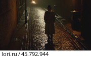 Mysterious man walking alone at night in a dark alley. Стоковое видео, видеограф Данил Руденко / Фотобанк Лори