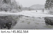Video of a winter landscape with the non-freezing Oda River into which natural springs and sources flow. Snow-covered riverbank and fields and forest in the distance. Winter travel and walks during the New Year holidays. Стоковое видео, видеограф Виктория Катьянова / Фотобанк Лори