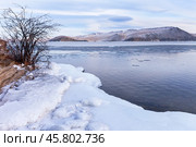 Scenic landscape of Baikal Lake in December during freeze-up. View of Olkhon Gate Strait with fields of floating ice and snowy hills of Olkhon Island in distance. Icy shore on frosty day. Natural background. Стоковое фото, фотограф Виктория Катьянова / Фотобанк Лори