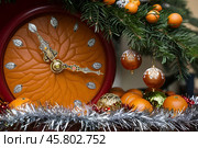 Tangerine clock under the tree counting down the time until the holiday. New Year as tangerine time. New Year and Christmas card. Стоковое AI-изображение, AI-художник Сергей Комаров / Фотобанк Лори