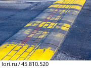 The Faded Yellow Crosswalk on the Asphalt Surface within the urban environment stands out distinctly. Стоковое фото, фотограф Аксенова Вера / Фотобанк Лори