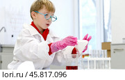 a student in a chemical laboratory conducts chemical sweats with chemical elements in. Стоковое фото, фотограф Igor Skripachev / Фотобанк Лори