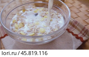 Whole grain cereal muesli in a bowl for a morning delicious breakfast with milk. Slow motion with rotation tracking shot. Стоковое видео, видеограф Андрей Армягов / Фотобанк Лори
