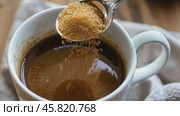 Person adding cane sugar with a spoon to cup of fresh aromatic coffee. Close up of teaspoon putting brown sugar into hot steamed drink mug. Sugar Being Poured into Cup of Coffee Americano, Close-Up. Стоковое AI-видео, аниматор Марина Демидюк / Фотобанк Лори