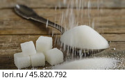 Sugar pile in a metal spoon on a wood surface. White granulated sugar and cubes. Natural seasoning. Refined sugar poured on wooden rustic table. Sugary sand. Cooking, cosmetology, spa services concept. Стоковое AI-видео, аниматор Марина Демидюк / Фотобанк Лори