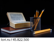 Книга и карандаши на темном фоне. Стоковое фото, фотограф Антон Гаев / Фотобанк Лори