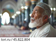 Portrait of a elderly muslim mullah immersed in prayer in the mosque. Shallow depth of field. Стоковое AI-изображение, AI-художник Михаил Строгалев / Фотобанк Лори