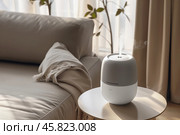 A sleek air humidifier in a modern living space. Shallow depth of field. Стоковое AI-изображение, AI-художник Михаил Строгалев / Фотобанк Лори