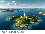 Aerial view of landscape of archipelago of islands with lighthouse in north sea, skyline at blue sky background. Amazing natural wild scenery view of Scandinavian nature concept. Copy ad text space. Стоковое AI-изображение, AI-художник Aleksandr Golubev / Фотобанк Лори