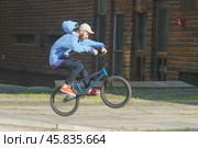 BMX in the Moscow park. Young man doing trick on the bike in the summer day. Extreme sports is very popular among youth. 2019. Редакционное фото, фотограф YuryKara / Фотобанк Лори