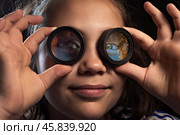 Маленькая девочка с линзами от бинокля крупным планом. Стоковое фото, фотограф RF / Фотобанк Лори