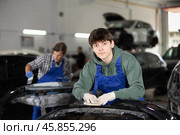 Young auto body technician sanding car bumper with sandpaper. Стоковое фото, фотограф Яков Филимонов / Фотобанк Лори